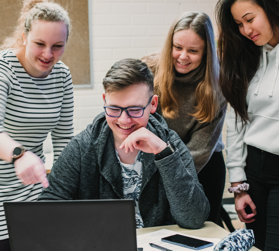 fyra gymnasiestuderanden ser pa en laptop